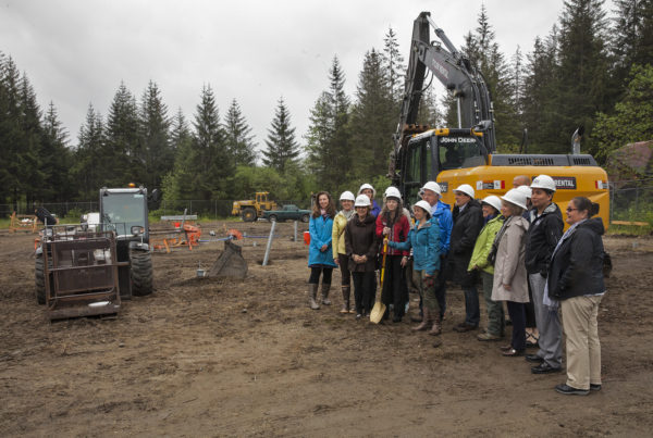 Representatives from several agencies working to bring a Housing First project to fruition pose for a photograph during a groundbreaking ceremony on Monday May 16, 2016 to celebrate the construction of the facility in Juneau, Alaska. The Juneau Housing First Collaborative is overseeing the project which will put a 32-unit facility in place. (Photo by Rashah McChesney, KTOO - Juneau)