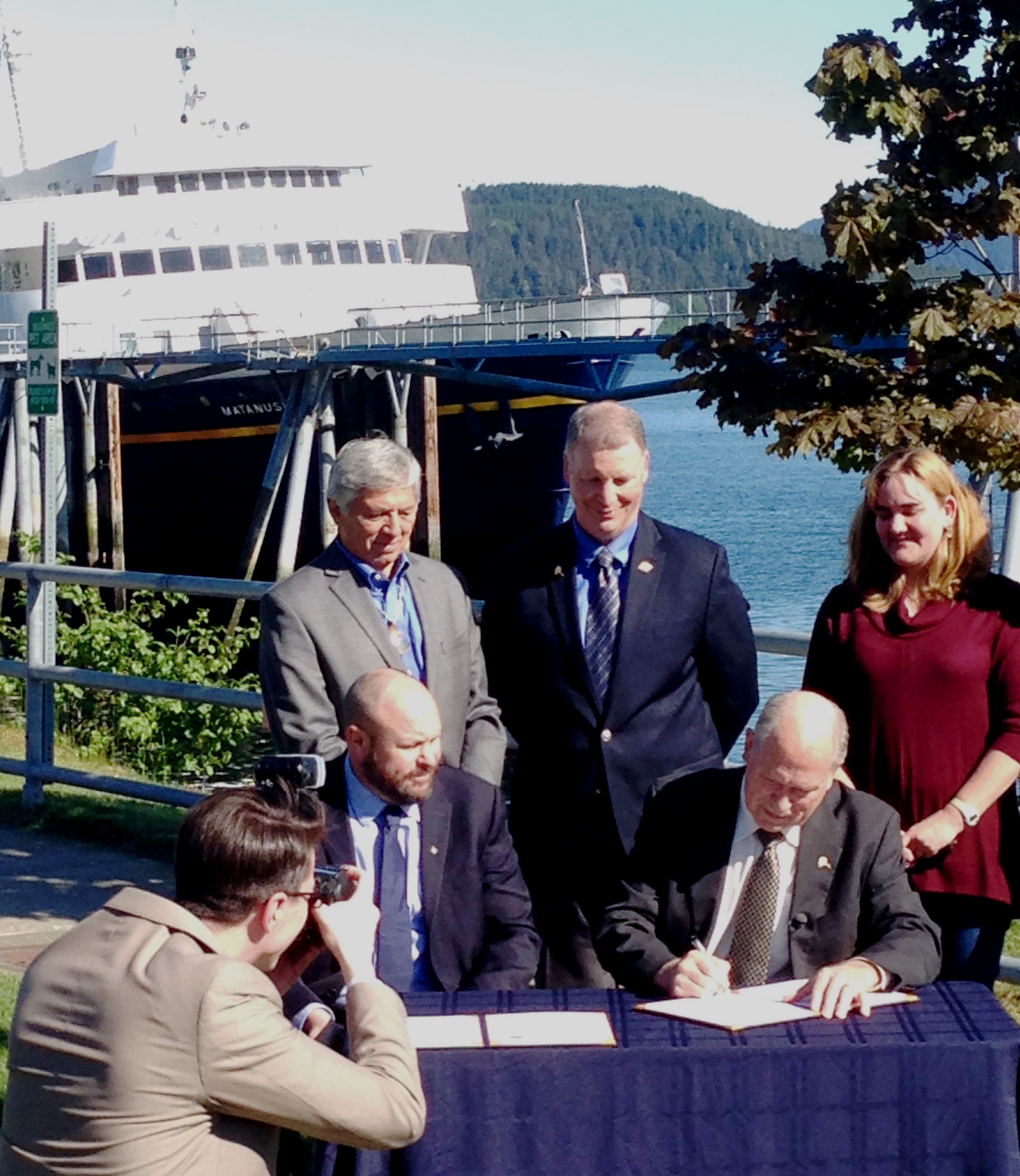 Gov. Bill Walker signs a memorandum of understanding with the Southeast Conference as its President, Gary White,and others watch Thursday at the Auke Bay Ferry Terminal. (Photo by Ed Schoenfeld, CoastAlaska - Juneau)