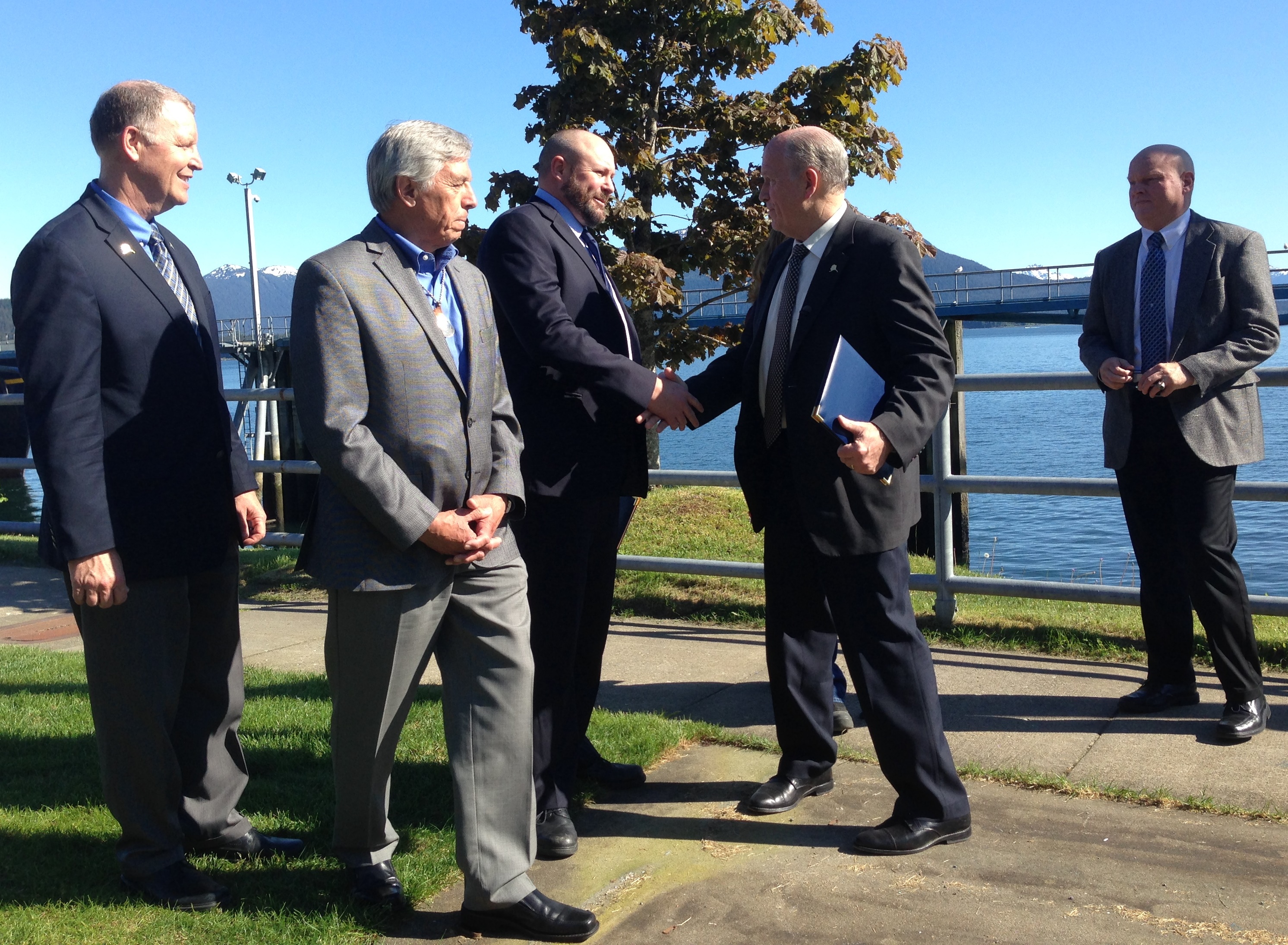 Gov. Bill Walker shakes hands with Southeast Conference President Gary White on Thursday at the Auke Bay Ferry terminal after signing an agreement to consider changes to Marine highway management. Transportation Commissioner Marc Luiken, left, Lt. Gov. Byron Mallott, second from left, and ferry Capt. Mike Neussl, right, look on. (Photo by Ed Schoenfeld,CoastAlaska - Juneau)