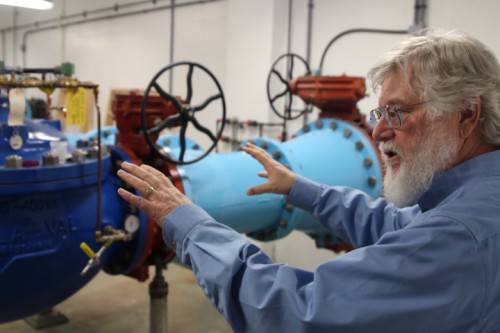 Project engineer Stephen Weatherman explains how all of Sitka’s water is run through the 24-inch pipes in the plant. (Photo by Robert Woolsey, KCAW - Sitka)