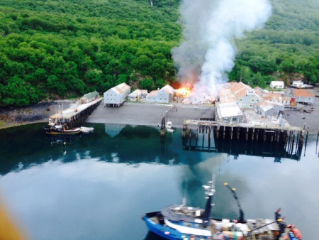 Responders assess a fire at the Park's Cannery near Uyak Bay on Kodiak Island, Alaska, June 2, 2016. The Coast Guard launched an MH-60 Jayhawk helicopter crew to assist with rescue efforts. (Photo courtesy of U.S. Coast Guard)
