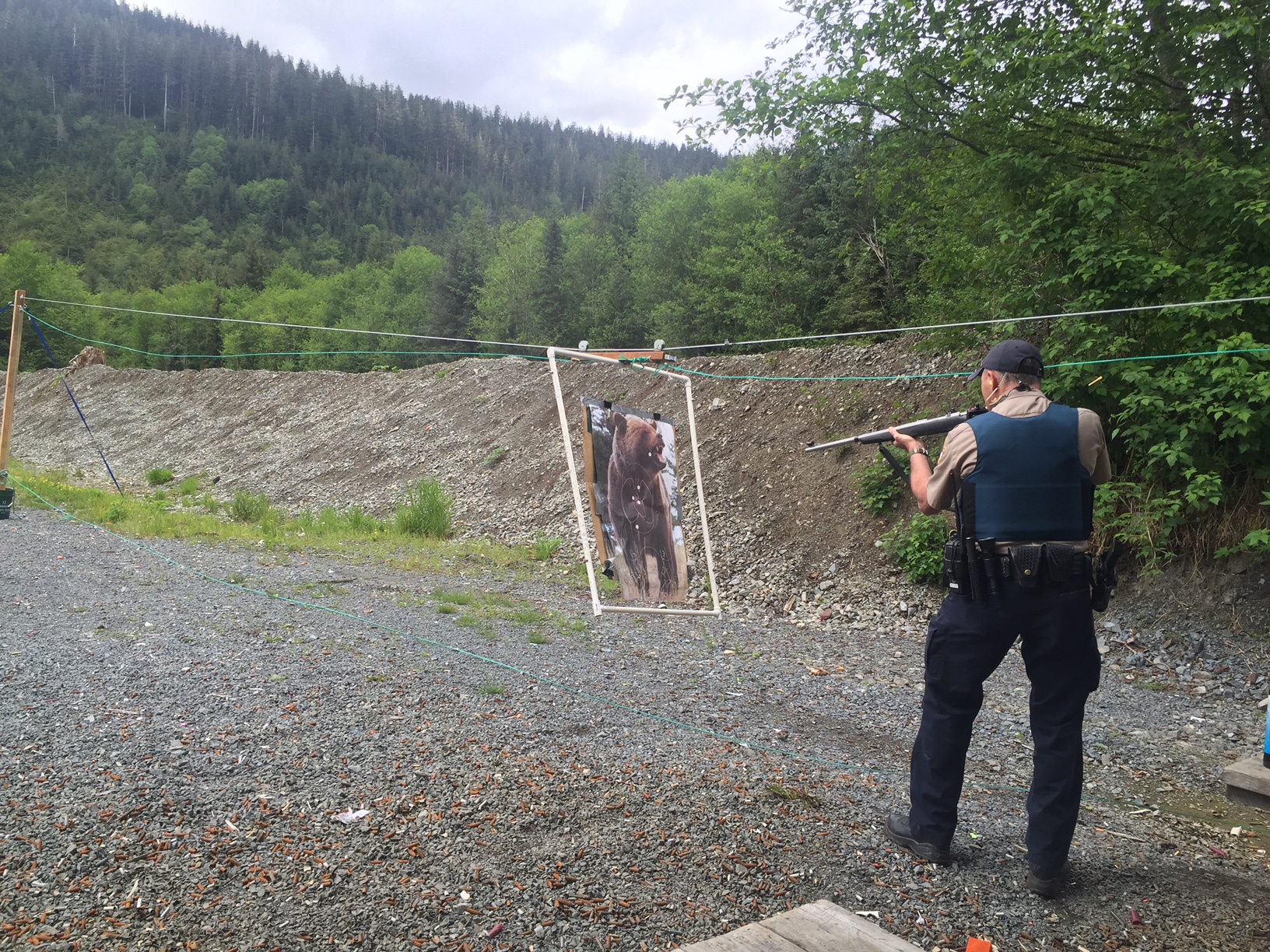 Alaska Wildlife Trooper Kyle Ferguson practices shooting the moving target at the Tony Hrebar Memorial Shooting range in Sitka. (Photo by Brielle Schaeffer, KCAW - Sitka)