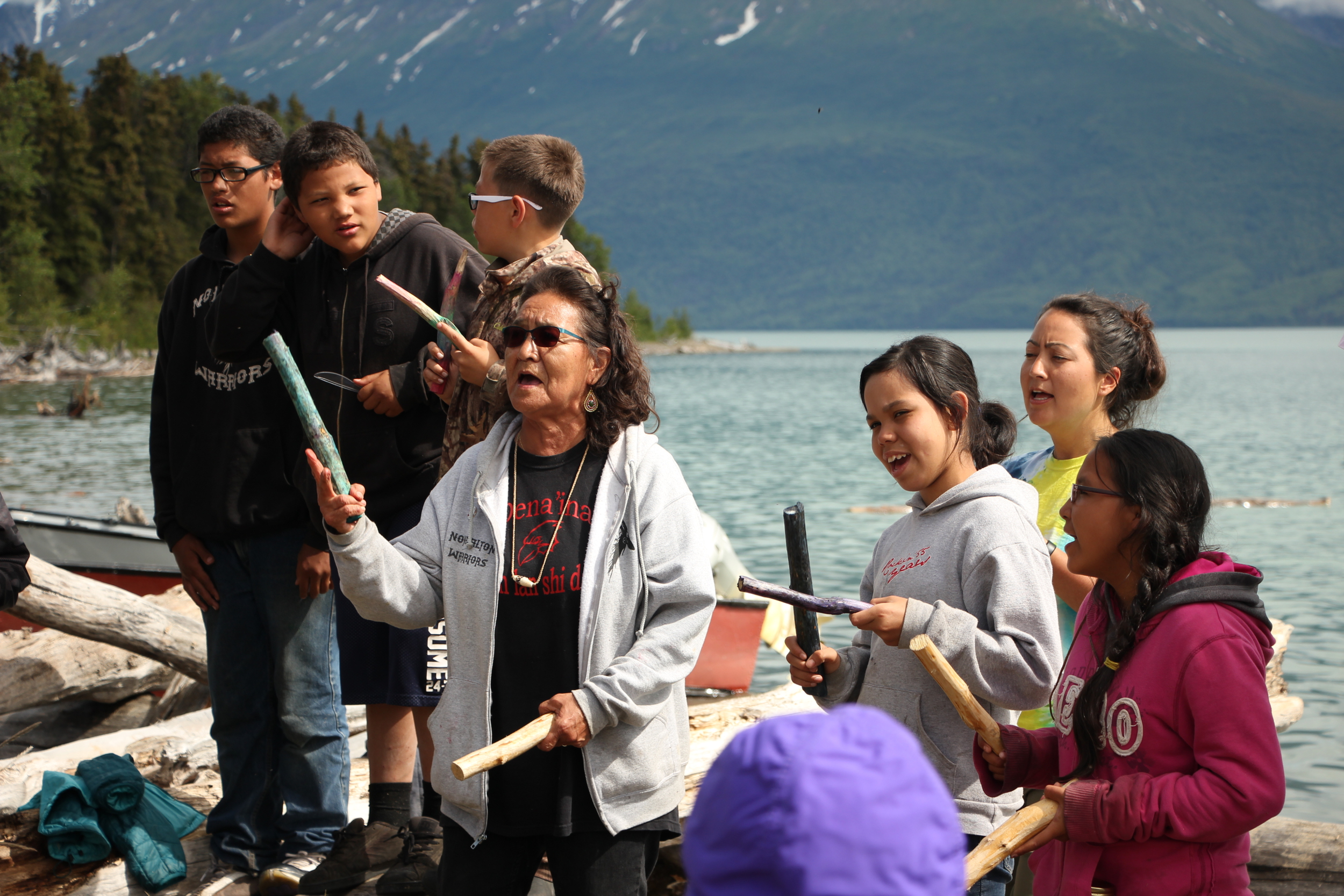 Michelle Ravenmoon (right), Nondalton elder Pauline Hobson (left) and kids sing a Dena'ina song at the end-of-camp potluck (Photo by Hannah Colton, KDLG - Dillingham)