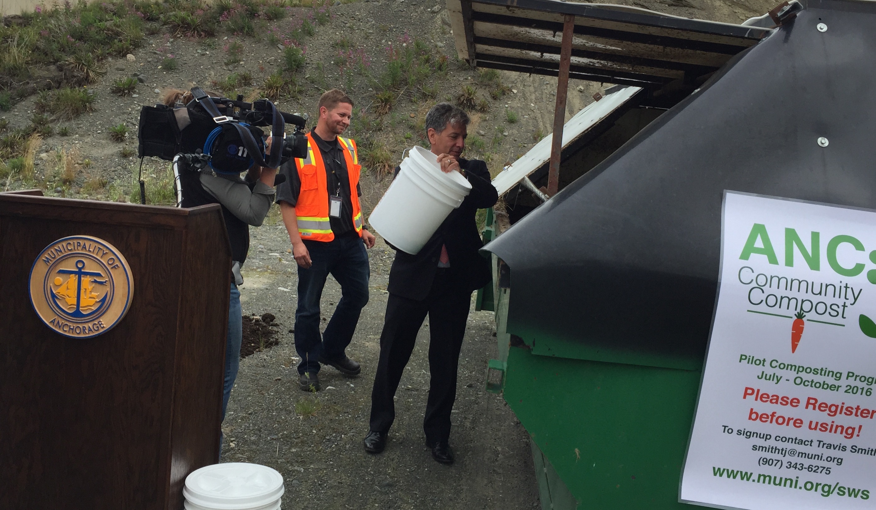 Mayor Berkowitz throwing in the first bucket of food scraps. SWS Director Mark Spafford is in the background. (Photo courtesy of SWS Recycling)