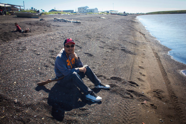 Bernard Abouchuk sits on the beach in Stebbins waiting for a seal. (Photo by Emily Russell, KNOM - Nome)