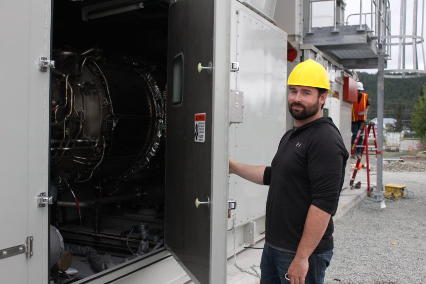 Bryan Farrell, an engineer at AEL&P, holds open the hatch to the diesel turbine. (Photo by Elizabeth Jenkins, KTOO - Juneau)