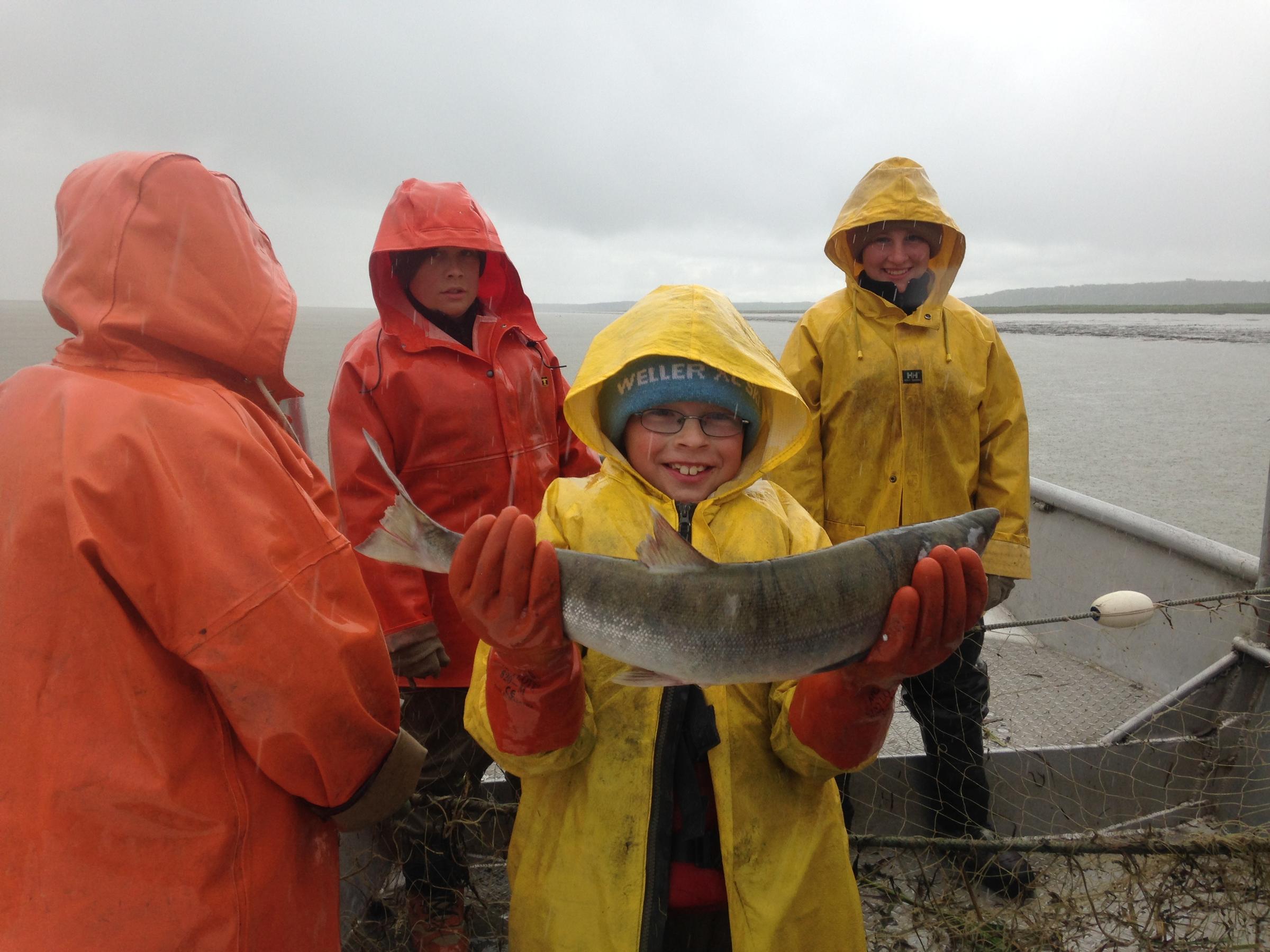 James Shawcroft holds up what might have been the 2,000,000,000th commercially caught salmon in Bristol Bay's history. At Coffee Point, July 6, 2016. (Photo by KDLG)