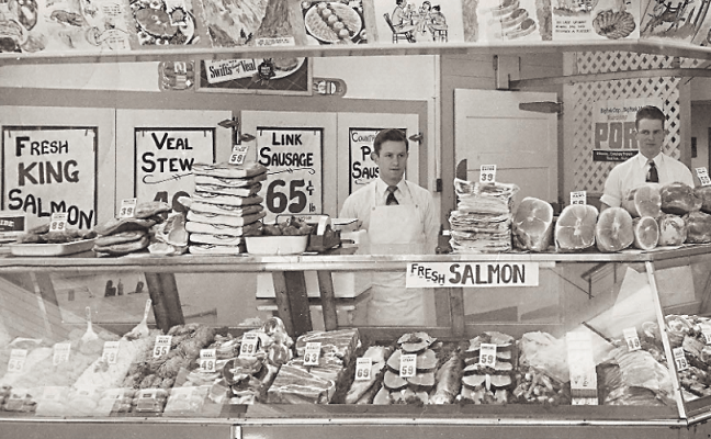 Bill Cope (right) and a butcher shop employee pose in 20th Century Market in downtown Juneau around 1950. (Photo courtesy of Violet Cope and featured on cover of Alaska Economic Trends, July 26, Volume 36 number 7.)