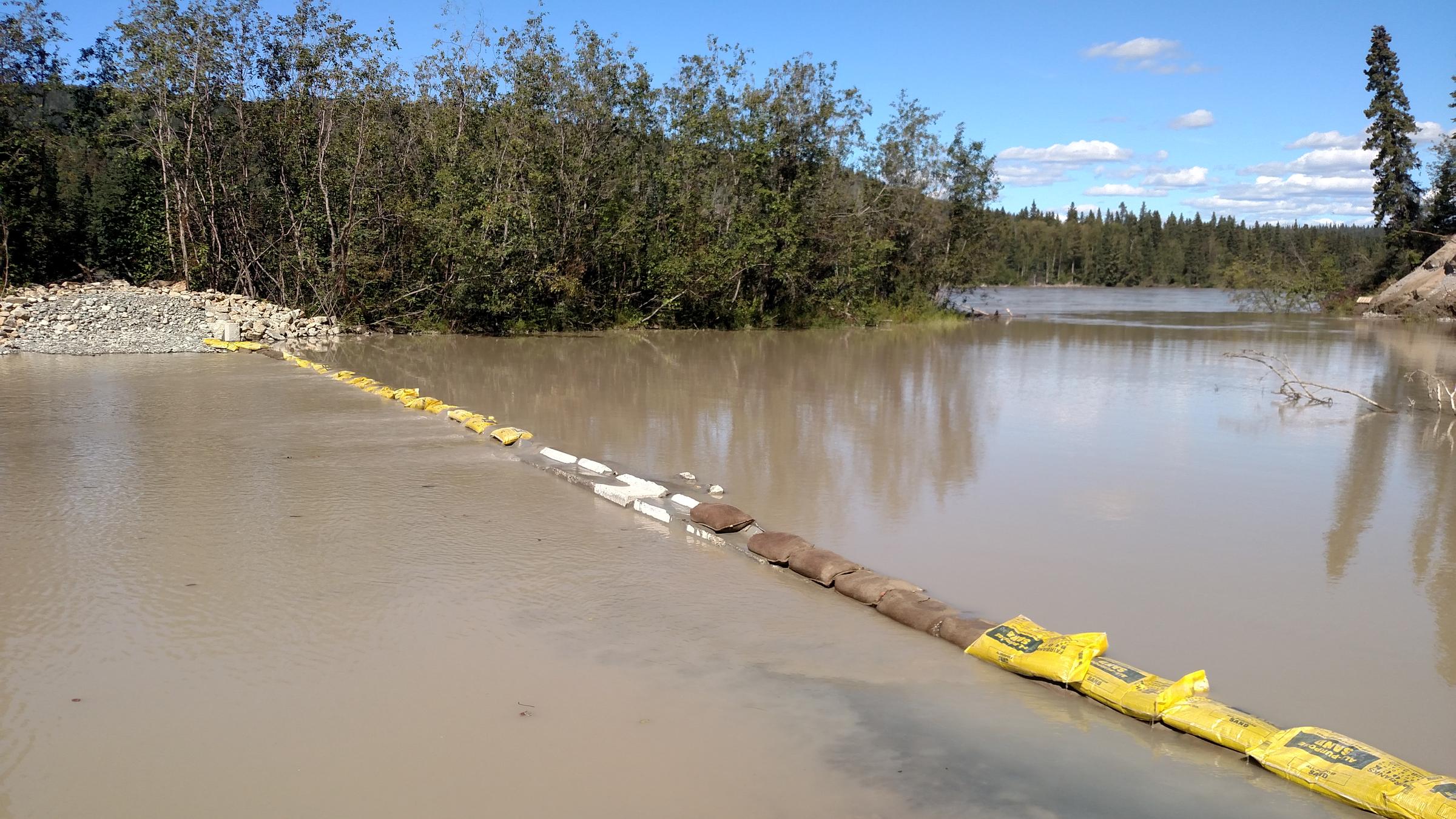 The 8-foot-tall dam that Gorman built earlier this year across the slough was submerged after recent rains raised the Tanana River level. Gorman laid a course of sandbags over the top of the structure to slow the river current and the erosion it causes. "It's holding," Gorman says. (Photo by Tim Ellis, KUAC - Fairbanks)