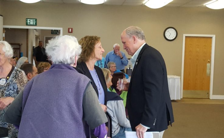 Governor Bill Walker greets Carol Swartz, Director of Kachemak Bay Campus-Kenai Peninsula College, University of Alaska Anchorage at the joint meeting of Homer's two Rotary clubs at Lands End Resort in Homer on Tuesday, August 2. (Shahla Farzan, KBBI - Homer)