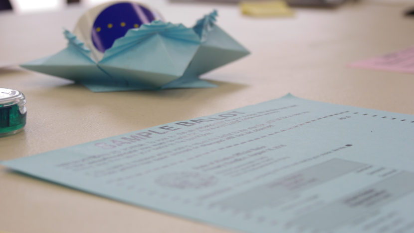 An origami "I Voted" sticker dispenser among the sample ballots at an absentee and early voting polling place in the State Office Building, Aug. 15, 2016. (Photo by Jeremy Hsieh, KTOO - Juneau)