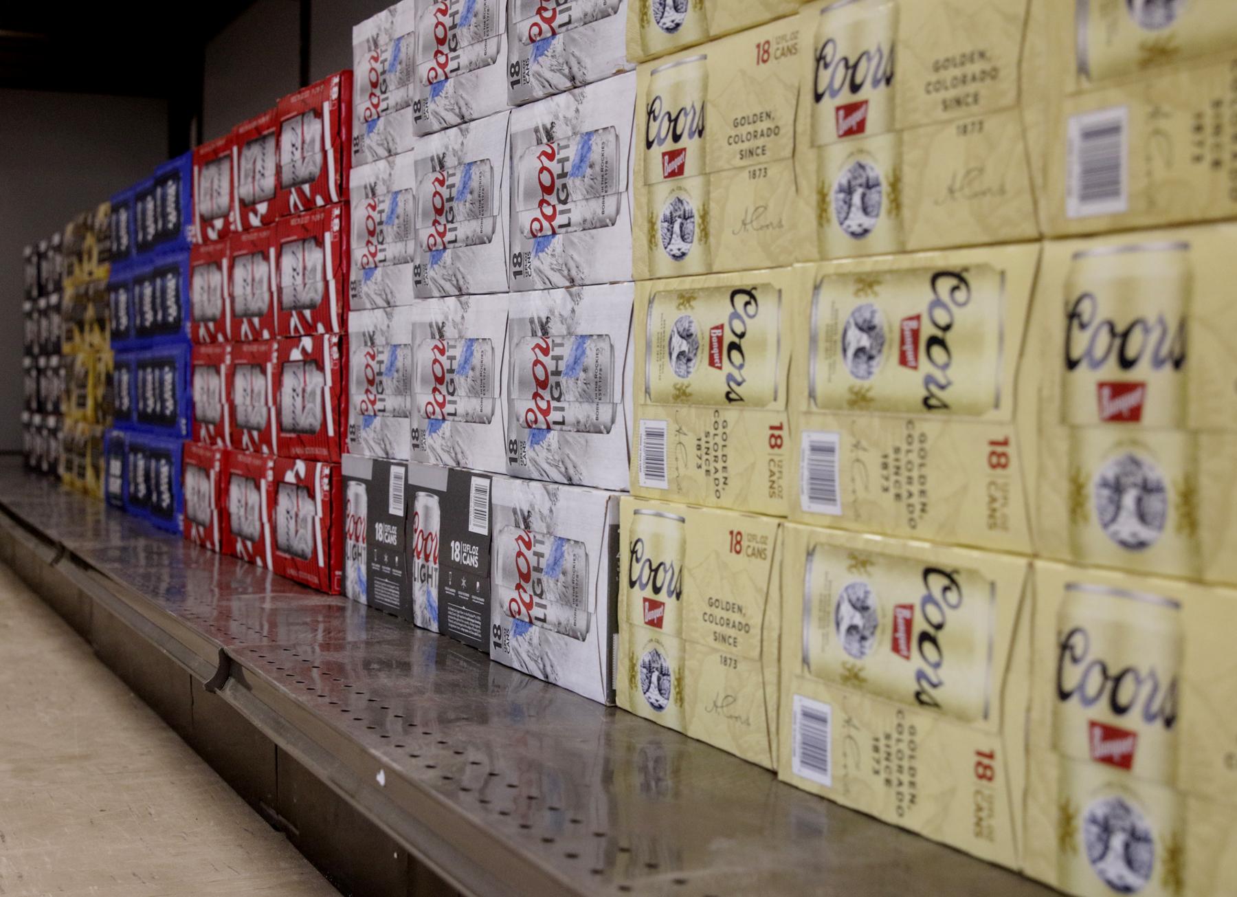 Eighteen packs of canned beer line the shelves at the opening of BNC's liquor store, Bethel Spirits, on Sept. 27, 2016. (Photo by Dean Swope, KYUK - Bethel)
