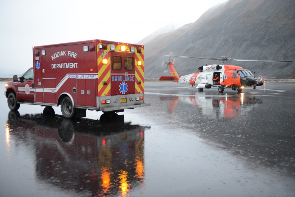 A Coast Guard Air Station Kodiak, Alaska, MH-60 Jayhawk helicopter crew transfers a patient to an ambulance in Kodiak after a medevac from a fishing boat in February 2016. (U.S. Coast Guard photo by Petty Officer 3rd Class Lauren Steenson)