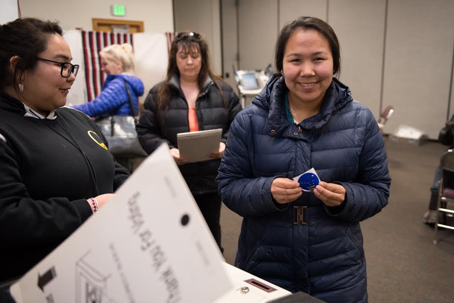 a person holds a voting sticker in a polling place