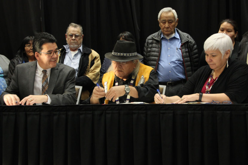 Deputy Interior Secretary Michael L. Connor joins Christopher Gene (center) and Karen Linnell of the Ahtna Intertribal Resource Commission to sign an agreement giving Alaska Native tribes in the Ahtna region more say over subsistence resources. (Photo by Rachel Waldholz, Alaska’s Energy Desk - Anchorage)