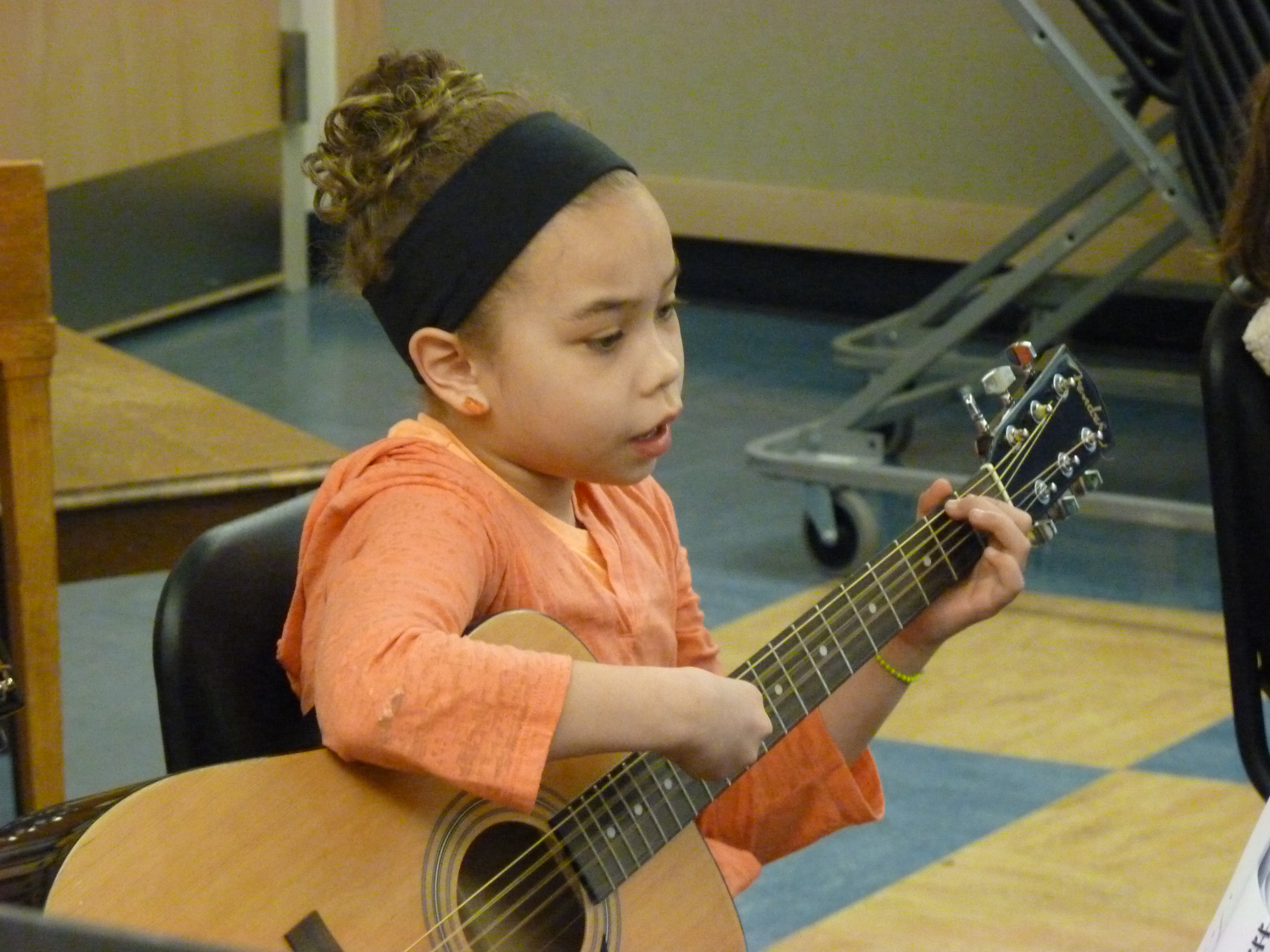Gastineau Elementary School student Sophia Lundeman sings and plays guitar during a music class led by Patrick Murphy (Photo by Ed Schoenfeld, CoastAlaska News)