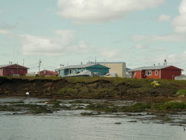 Homes stand close to an eroding river bank