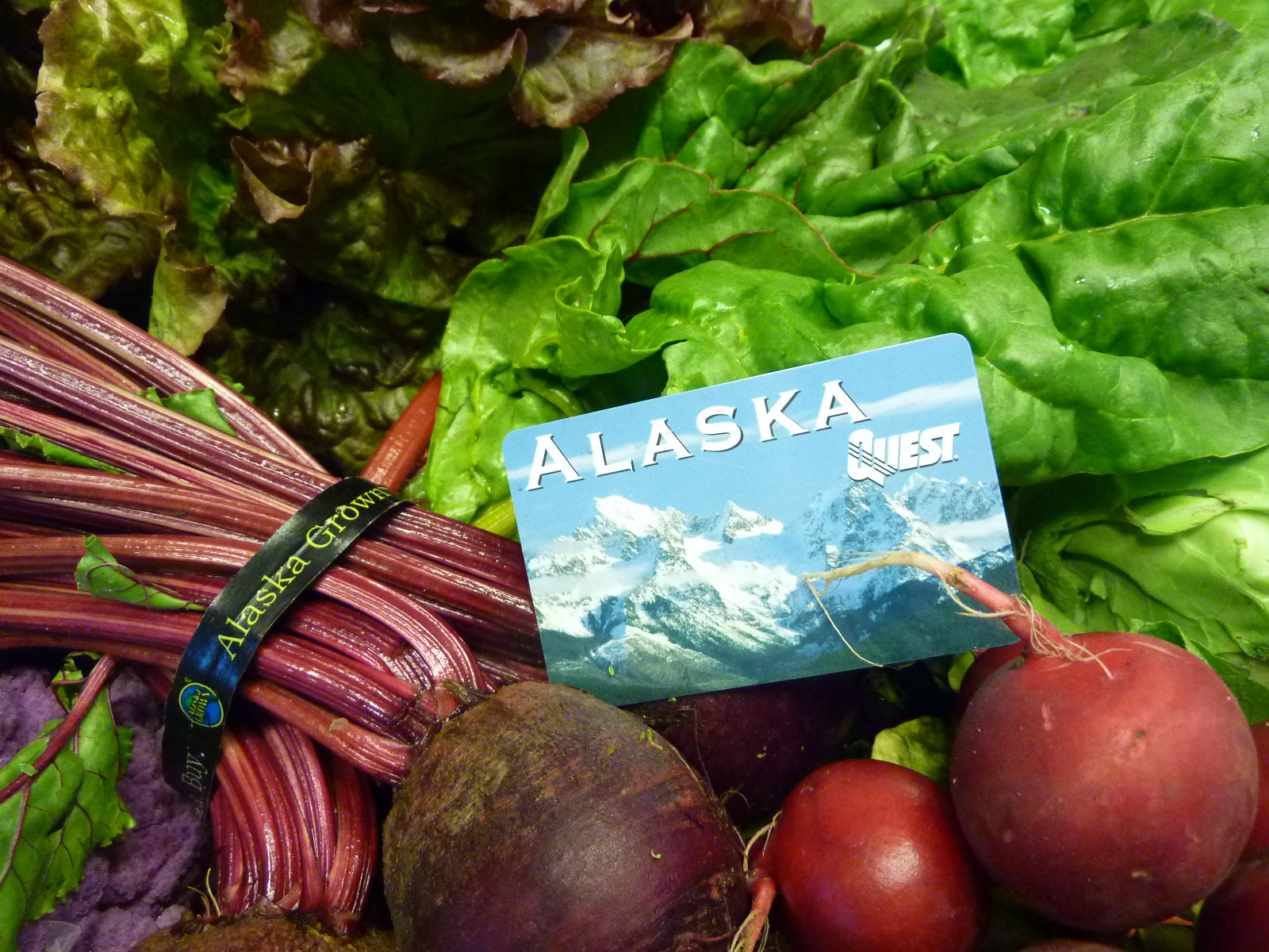 a credit card-style Alaska Quest Card on fresh produce