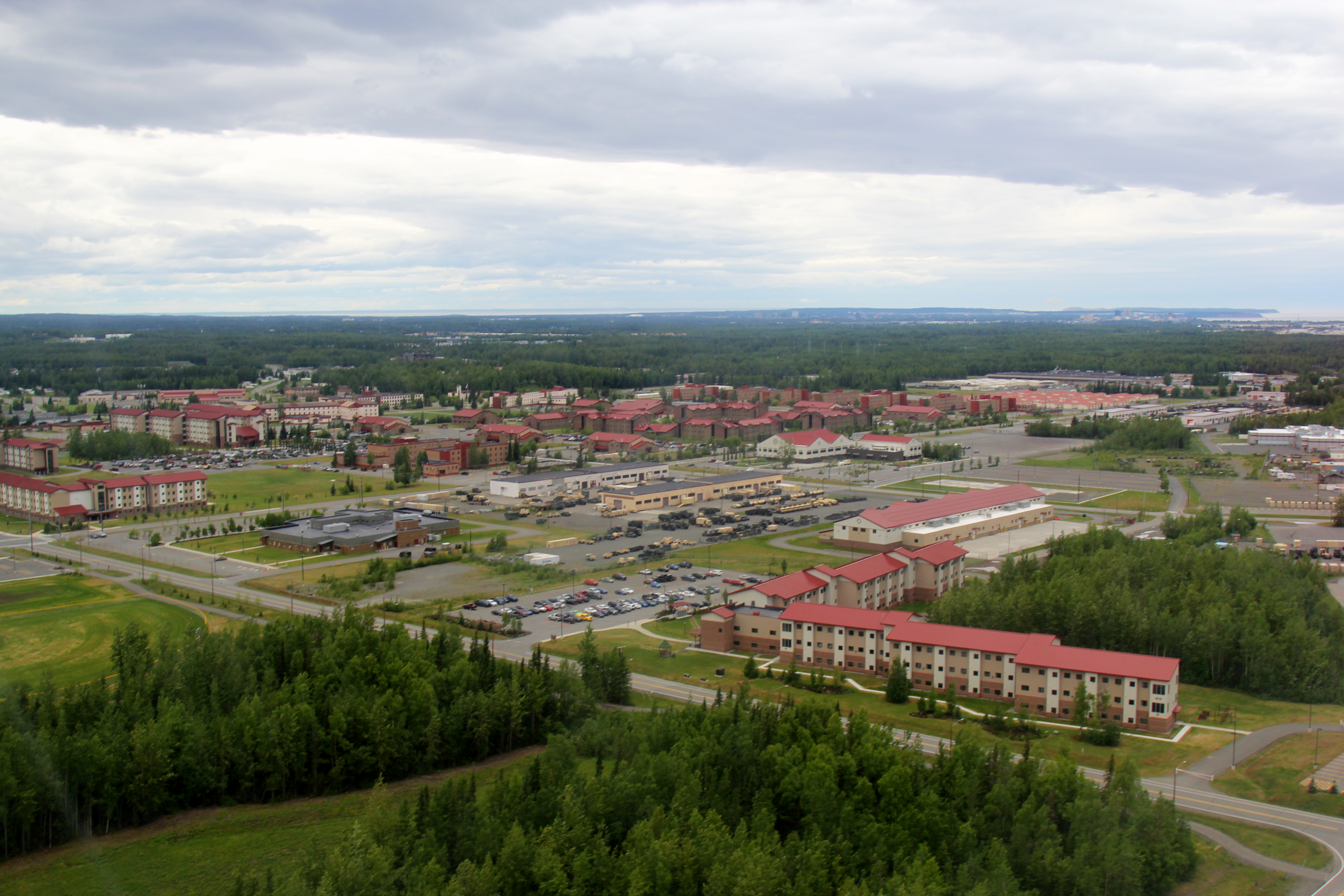 an aerial view of multi-story buildings and parking lots on a miliatry base
