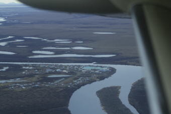 a river with a small town on the oxbow as seen from an airpllane. 