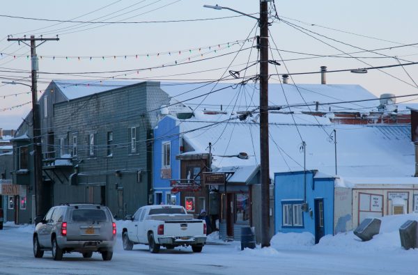 A snowy street near several bars