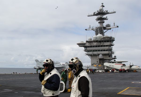 Two men walking on the deck of an aircraft carrier