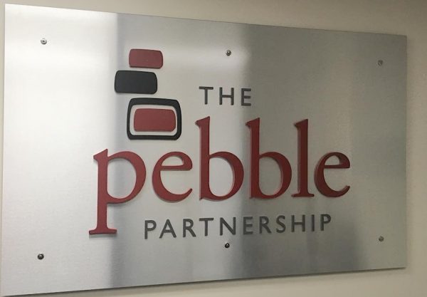 A silver sign that says "The Pebble Partnership"