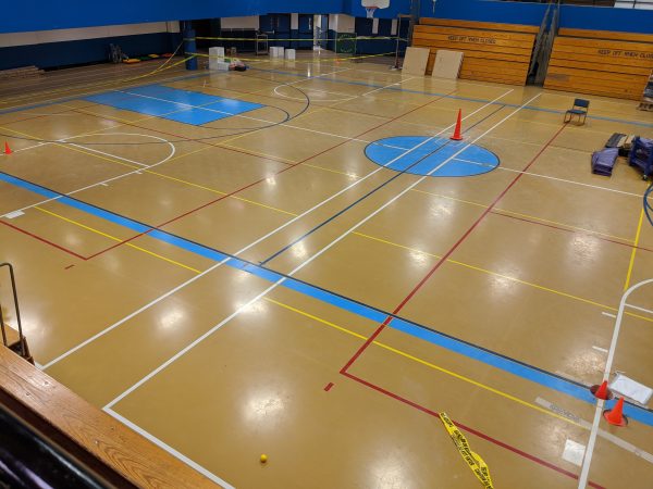The Gruening Middle School gym floor. Traffic cones indicated where geotechnical engineers drilled through the floor into the soil to check for any geotechnical issues beneath the school