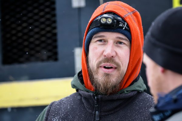 A man in a hat and orange hood.
