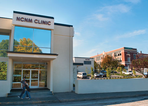 Two students walk past the 'NCNM Clinic' building in Portland, Ore.