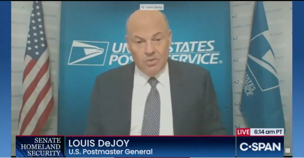 Screenshot of Louis DeJoy with the insignia of the Postal Service behind him.
