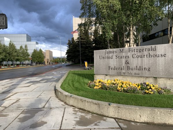 The sign outside the federal courthouse in Anchorage along 7th Avenue with the museum in the background