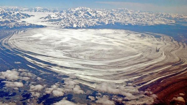 A glacier seen from the air with large bowed striations coing out iniot ht ebay