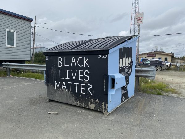 A dumpster with Black Lives Matter ppaitned on the front in white letters