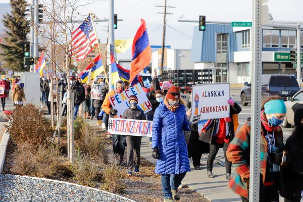 a group of people marching and holding signs and flags