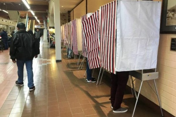 Voters mark their ballots in a long hallway