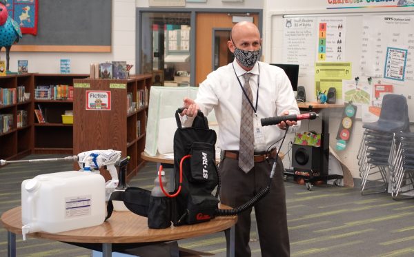 Rob Holland, Anchorage School District director of maintenance and operations, describes the different sanitation equipment that will be used at schools. He is holding a high-volume disinfectant sprayer.