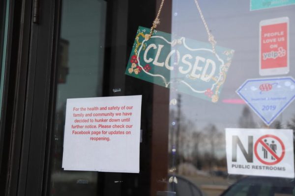 Signs in a window announce covid closures