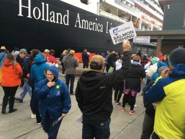 Crowds of people at the dock next to a Holland American ship