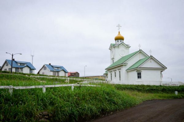 A white wooden church with a golden onion dome