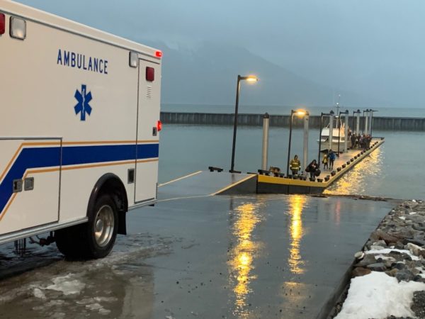 An ambulance backing into a dock on a rainhy day