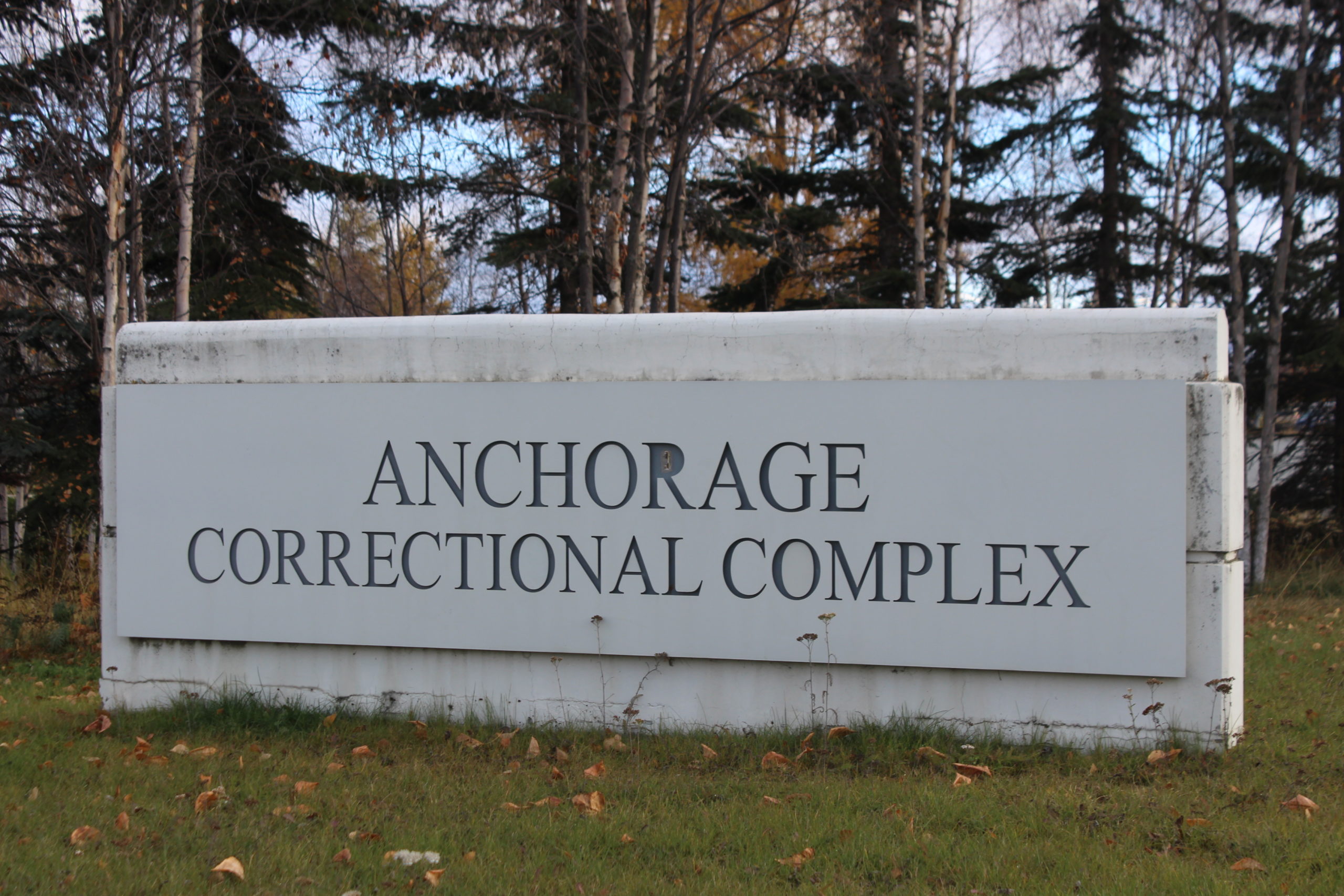 A concrete sign with the words "Anchorage Correctional Complex_