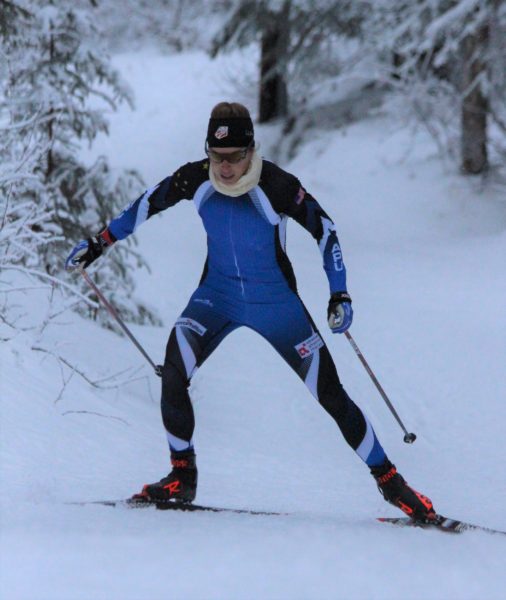A skier ina blue lycra suit on an uphill