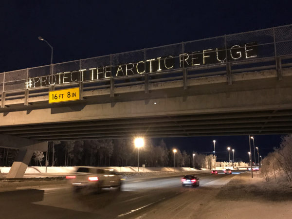 light-boards spell out "#ProtectTheArcticRefuge" over a highway