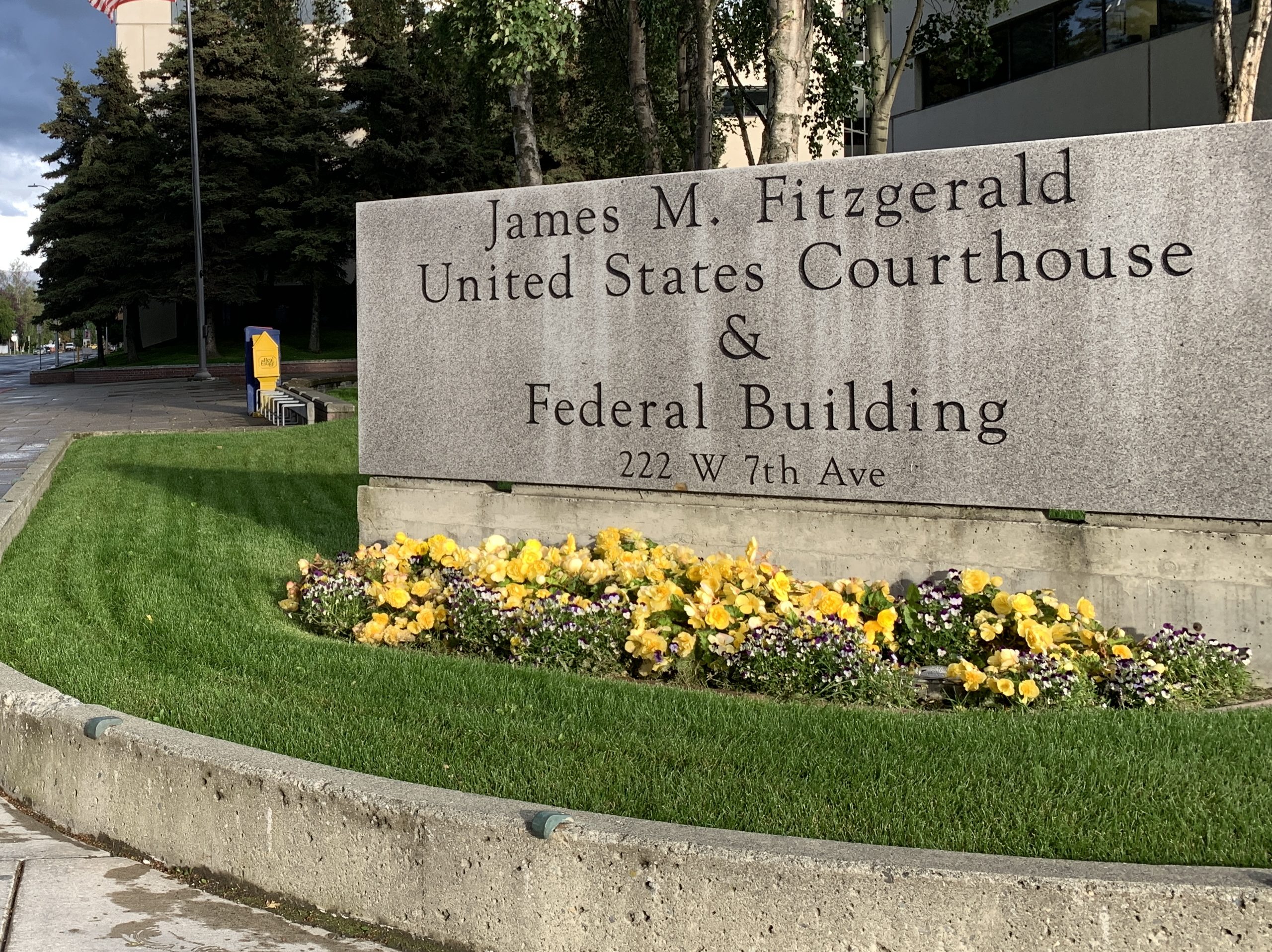 The sign outside the federal courthouse in Anchorage along 7th Avenue with the museum in the background