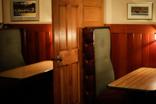 Wooden doors separate two booths.