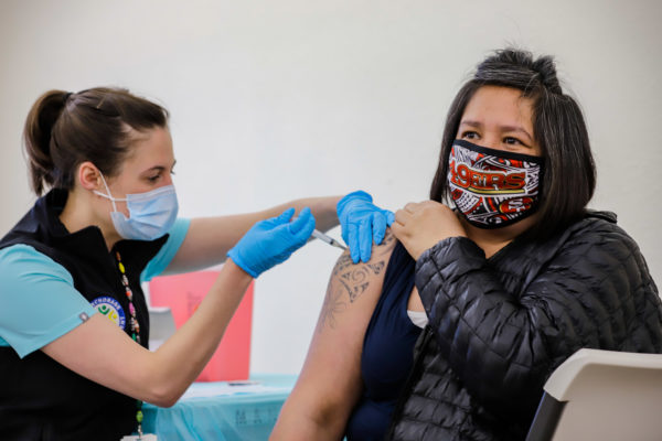 a nurse administers a vaccine to a patient