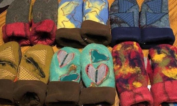 Six pairs of mittens lined up on the table with unique patterns