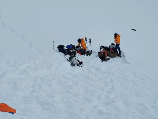Two people with helicopters and sleds at a snowfield