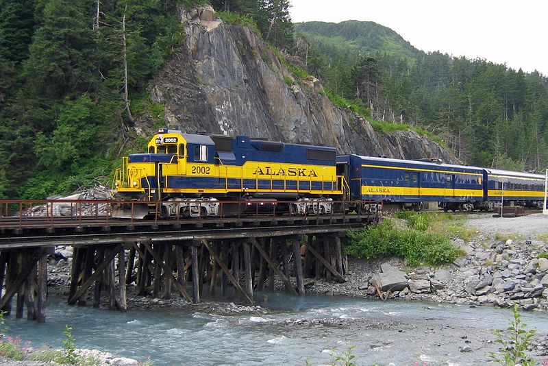 A train goes over a creek in a mountainous area